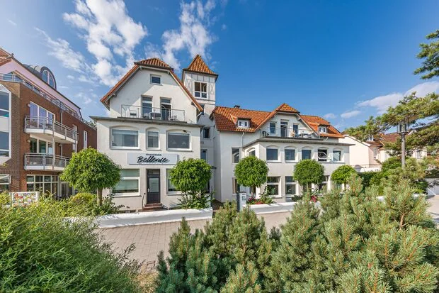 Luftaufnahme der Strandburg Bellevue an der Strandpromenade von Niendorf mit Sandstrand und Ostsee